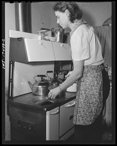 Penasco, New Mexico. Marjorie Muller, Red Cross nurse, does her own cooking in her one-room home adjoining the clinic operated by the Taos County cooperative health association