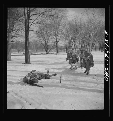 Carlisle, Pennsylvania. Demonstration before Army doctors and officer candidates at the U.S. Army medical field service school. Company aid man has marked this "wounded" man with a tag on his bayonet so he will be picked up by approaching litter bearers