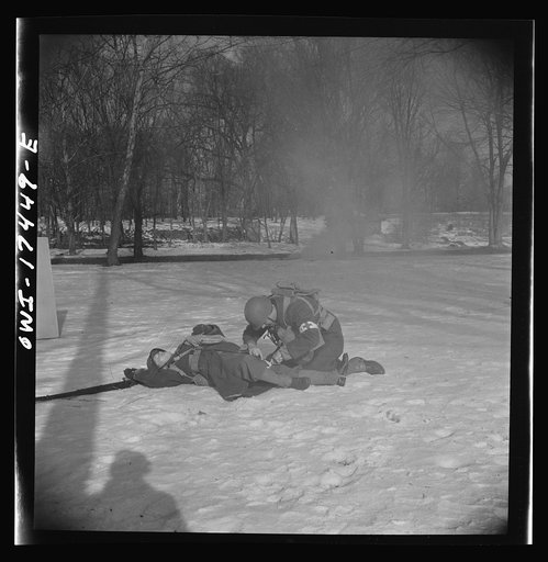 Carlisle, Pennsylvania. Demonstration before Army doctors and officer candidates at the U.S. Army medical field service school. Company aid man has marked this "wounded" man with a tag on his bayonet so he will be picked up by approaching litter bearers