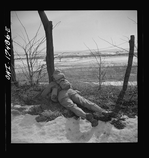 Carlisle, Pennsylvania. U.S. Army medical field service school. Officer candidate who has taken shelter at the side of the road after being "flour bombed" by a plane during a road march. Men are taught to disperse singly