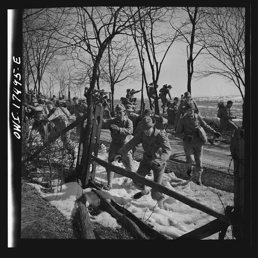 Carlisle, Pennsylvania. U.S. Army medical field service school. Officer candidates during a practice road march carrying full packs, disperse singly to side of road while being "attacked" by flour bombs