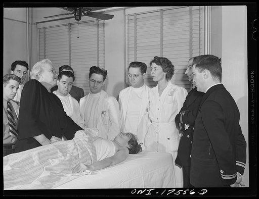 Untitled photo, possibly related to: Minneapolis, Minnesota. Sister Kenny conducting a class for doctors and nurses at the Elizabeth Kenny Institute. The two men in uniform are medical officers of the United States Coast Guard who came to the institute to see a patient and stay for the class