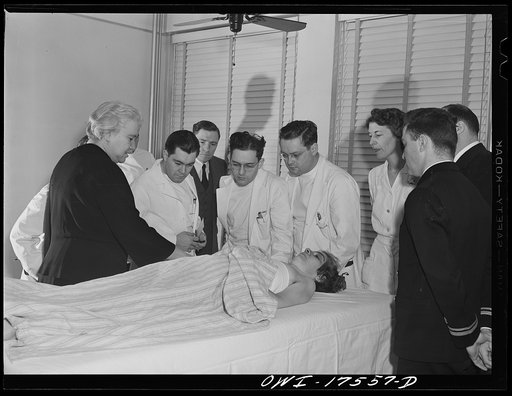 Minneapolis, Minnesota. Sister Kenny conducting a class for doctors and nurses at the Elizabeth Kenny Institute. The two men in uniform are medical officers of the United States Coast Guard who came to the institute to see a patient and stay for the class