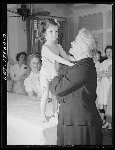 Minneapolis, Minnesota. Sister Kenny with two-year-old Winifred Gorman, a patient at the Kenny Institute. Winifred was admitted in November, 1942, a very serious case, stricken with infantile paralysis in both legs, spine and abdomen. She can now walk and use her arms freely. She is almost completel