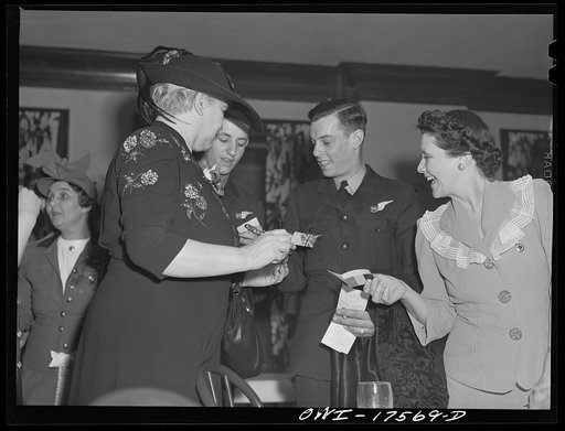 Minneapolis, Minnesota. Sister Kenny signing autographs at an American Legion meeting at which she was the principal speaker. With her (in uniform) are Sergeant C.N. Macqueen, from Sidney, and Sergeant J. Rutherford, from Brisbane, both of the Australian Air Force