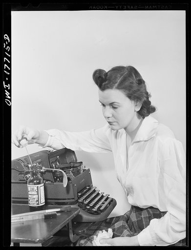 Washington, D.C. A government secretary in the United States Office of Emergency Management (OEM) cleaning her typewriter