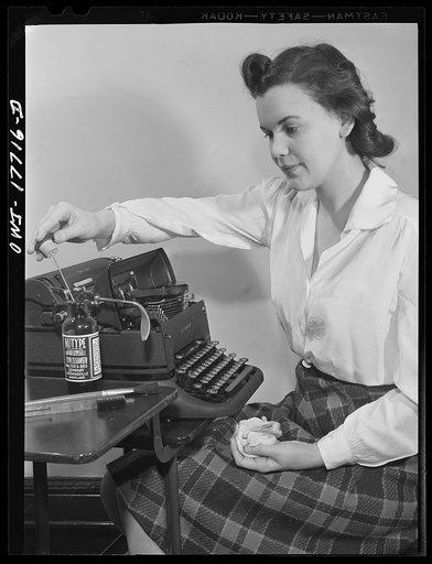 Washington, D.C. A government secretary in the United States Office of Emergency Management (OEM) cleaning her typewriter