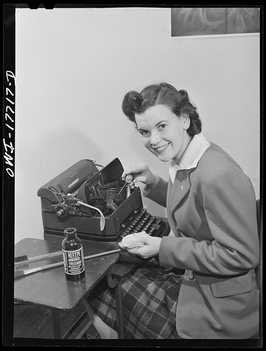 Washington, D.C. A government secretary in the United States Office of Emergency Management (OEM) cleaning her typewriter