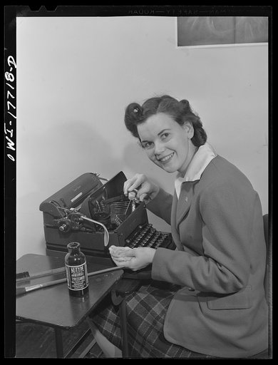 Washington, D.C. A government secretary in the United States Office of Emergency Management (OEM) cleaning her typewriter