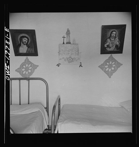 Trampas, New Mexico. In the home of Juan Lopez, the majordomo (mayor) [i.e., steward]. Years ago ancient hand-carved and painted santos hung on the walls in place of these cheap religious prints. Collectors have bought up almost all native art