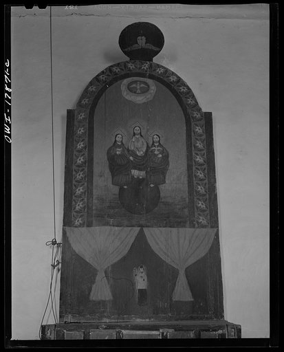 Trampas, New Mexico. Altarpiece of the Trinity on the left side facing the altar of a church which was built in 1700, and is the best-preserved colonial mission in the Southwest