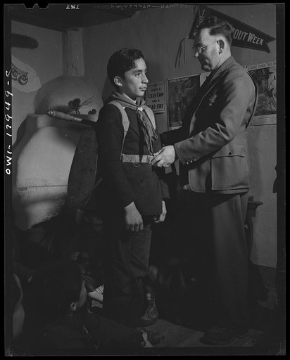 Untitled photo, possibly related to: Taos County, New Mexico. Father Cassidy, the Catholic priest of the parish of Penasco with his troop of Boy Scouts listening to the local forest ranger discussing conservation of their forests