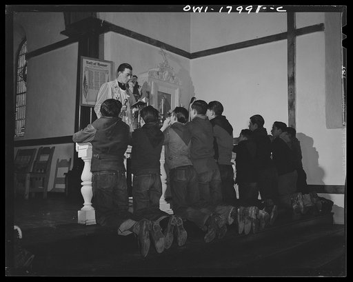 Taos County, New Mexico. Father Cassidy, the Catholic priest of the parish of Penasco, blessing the merit badges of his troop of Boy Scouts