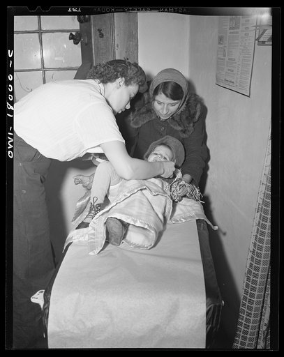Penasco, New Mexico. A nurse from the clinic operated by the Taos County cooperative health association making a hurried examination of a little girl who is dying of appendicitis before rushing her to the hospital in Taos