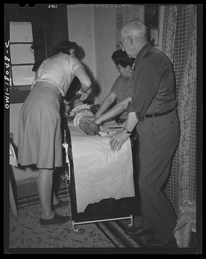 Untitled photo, possibly related to: Penasco, New Mexico. A nurse from the clinic operated by the Taos County cooperative health association making a hurried examination of a little girl who is dying of appendicitis before rushing her to the hospital in Taos