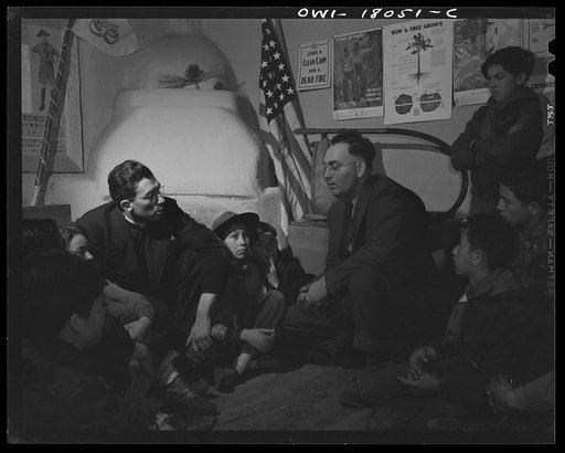 Untitled photo, possibly related to: Taos County, New Mexico. Father Cassidy, the Catholic priest of the parish of Penasco with his troop of Boy Scouts listening to the local forest ranger discussing conservation of their forests
