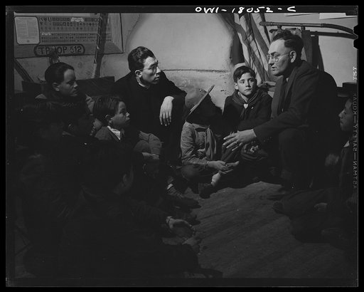 Untitled photo, possibly related to: Taos County, New Mexico. Father Cassidy, the Catholic priest of the parish of Penasco with his troop of Boy Scouts listening to the local forest ranger discussing conservation of their forests