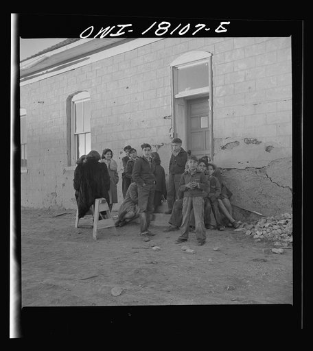 Questa, New Mexico. Natives listening to the evening news release from broadcasting station PSA, operated from the parish house by means of loudspeakers by Father Smith, priest to the parish of Questa