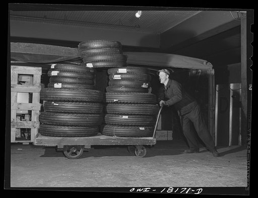 New York, New York. Associated Transport Company trucking terminal on Twenty-third Street. Loading tires onto a truck