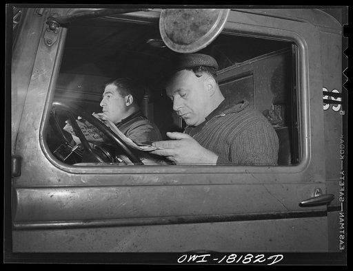 New York, New York. Associated Transport Company trucking terminal on Twenty-third Street. Local drivers sitting in a truck during lunch hour
