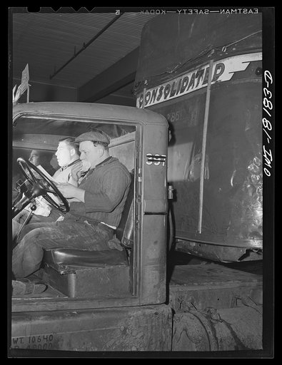 New York, New York. Associated Transport Company trucking terminal on Twenty-third Street. Local drivers sitting in a truck during lunch hour