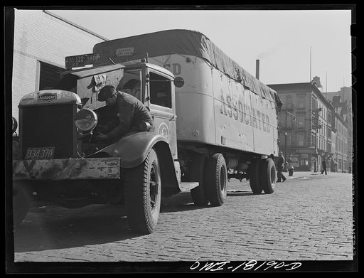 New York, New York. Associated Transport Company trucking terminal on Twenty-third Street. Mechanic checking the motor of a transport truck