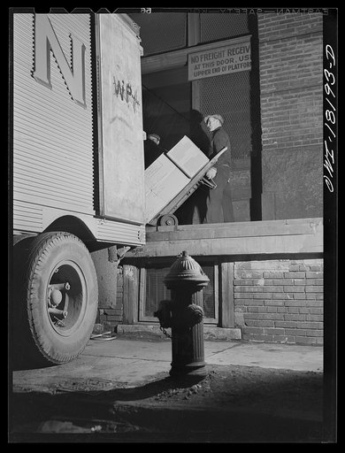 New York, New York. Associated Transport Company trucking terminal on Washington Street. Loading goods on a southbound transport truck