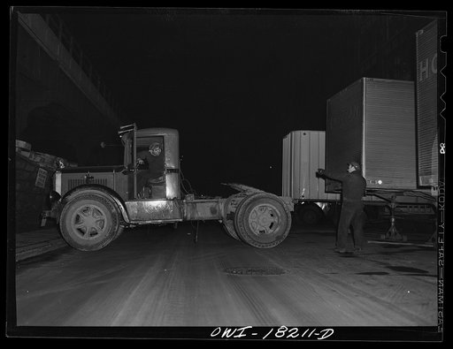 New York, New York. Associated Transport Company trucking terminal on Washington Street. Backing a tractor to a loaded trailer which is going south