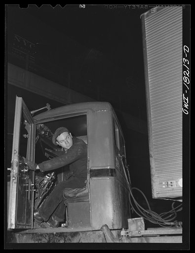 Untitled photo, possibly related to: New York, New York. Associated Transport Company trucking terminal on Washington Street. Attaching air lines from the tractor to the trailer