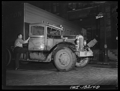 New York, New York. Associated Transport Company trucking terminal on Washington Street. Spotter preparing to move a loaded truck from the loading platform to a side street where it will be picked up by the driver who will take it to Baltimore