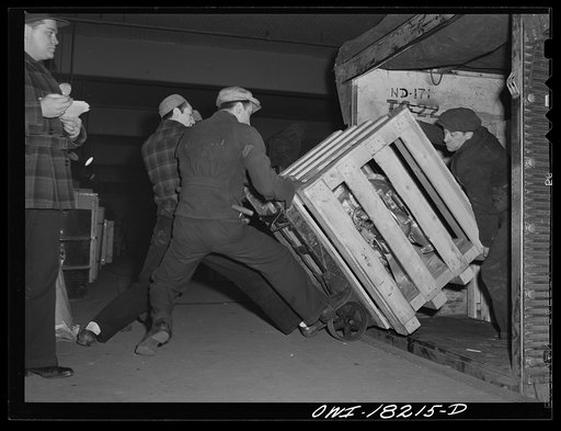 New York, New York. Associated Transport Company trucking terminal on Twenty-third Street. Unloading goods from a local truck