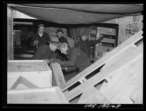 New York, New York. Associated Transport Company trucking terminal on Twenty-third Street. Unloading goods from a local truck