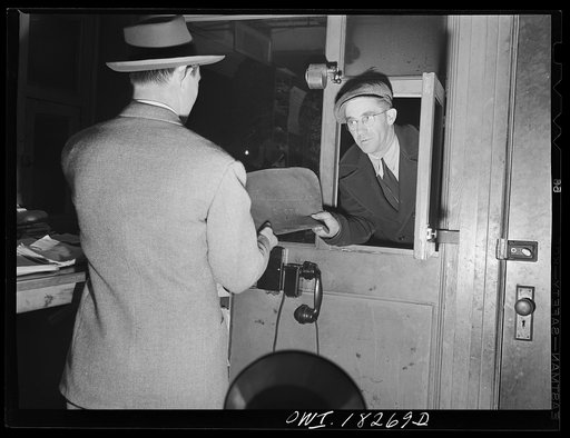 New York, New York. Associated Transport Company trucking terminal on Washington Street. Driver receiving his log from the dispatcher's office before starting out on a trip to Baltimore. This is a leather case containing the bills of lading for all the goods which he is to carry; it is not opened un