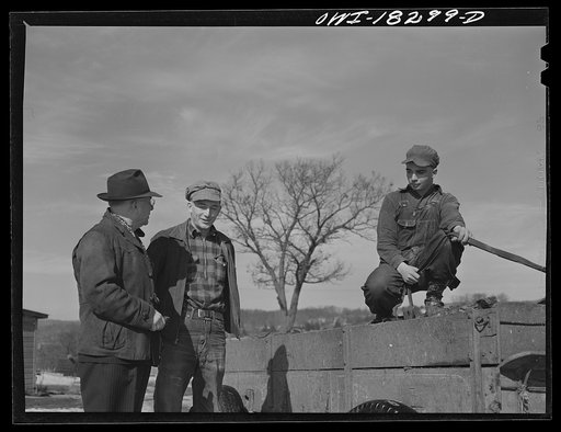 Farm Security Administration supervisor John Tormey, left, visiting the Wisconsin farm of Loren Colby (center), to discuss the progress of Harvey G. Berthold who was placed on the farm as a hired hand through the farm short course at the University of Wisconsin
