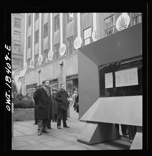 New York, New York. "United Nations" exhibition of photographs presented by the United States Office of War Information (OWI) on Rockefeller Plaza. Listening to broadcasts of President Roosevelt, Churchill, Stalin, and Chiang Kai-Chek, heard every half-hour from a loudspeaker at one end of the frame