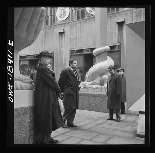 New York, New York. "United Nations" exhibition of photographs presented by the United States Office of War Information (OWI) on Rockefeller Plaza. Listening to broadcasts of President Roosevelt, Churchill, Stalin, and Chiang Kai-Chek, heard every half-hour from a  loudspeaker at one end of the fram