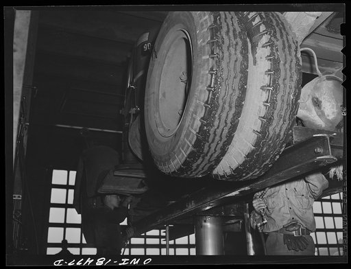 Untitled photo, possibly related to: Baltimore, Maryland. Davidson Transfer Company trucking terminal. Checking the tires on truck tractors