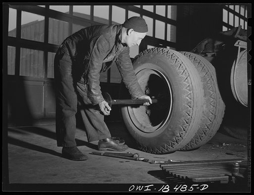 Baltimore, Maryland. Davidson Transfer Company trucking terminal. Removing an axle rod from a truck tractor in the service shop