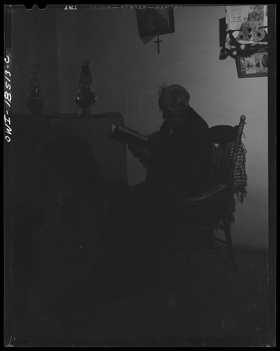Untitled photo, possibly related to: Trampas, Taos County, New Mexico. Grandfather Romero, the oldest man in the town, is ninety-nine years old (seated in room, reading)