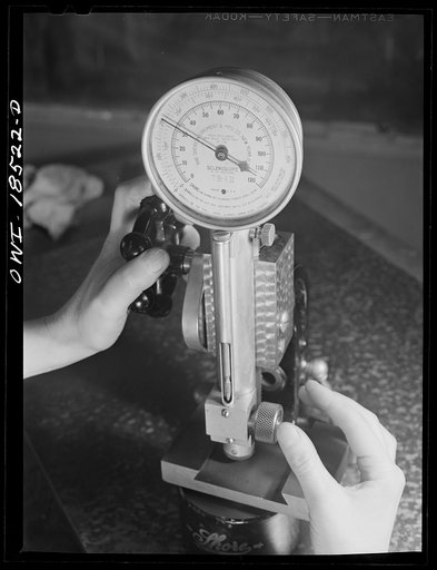 Untitled photo, possibly related to: New York, New York. Class in the use of precision instruments, part of the government-sponsored industrial training program at New York University. Most of the students are women. Testing diameter variations and concentricity of ground stepped shafts with a compa