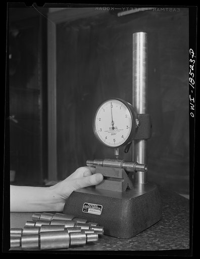 Untitled photo, possibly related to: New York, New York. Class in the use of precision instruments, part of the government-sponsored industrial training program at New York University. Most of the students are women. Testing diameter variations and concentricity of ground stepped shafts with a compa