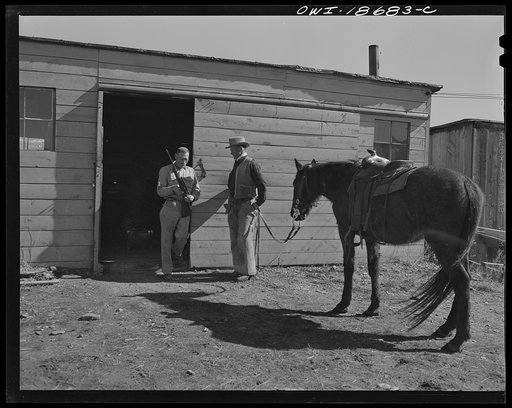 Moreno Valley, Colfax County, New Mexico. George Turner, a gunsmith as well as a cattleman, chatting in front of his shop