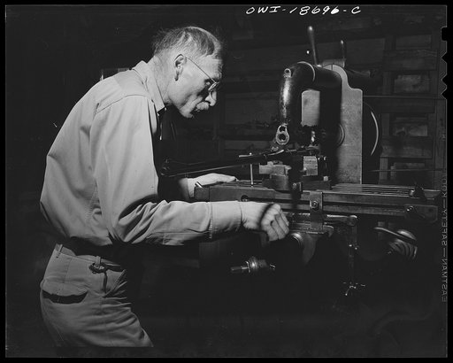 Moreno Valley, Colfax County, New Mexico. George Turner, a gunsmith as well as a cattleman, working a gun barrel on an electric lathe. He is adjusting a telescopic sight