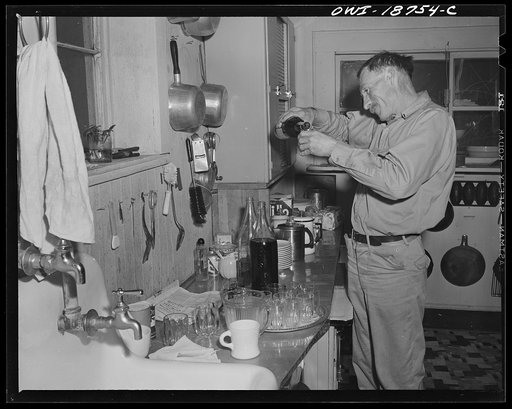Moreno Valley, Colfax County, New Mexico. George Turner pouring the drinks at a community poker and bridge party on his ranch