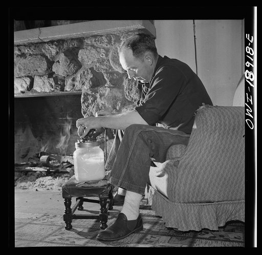 Moreno Valley, Colfax County, New Mexico. William Heck, a stockman, churning butter after a hard day in the saddle