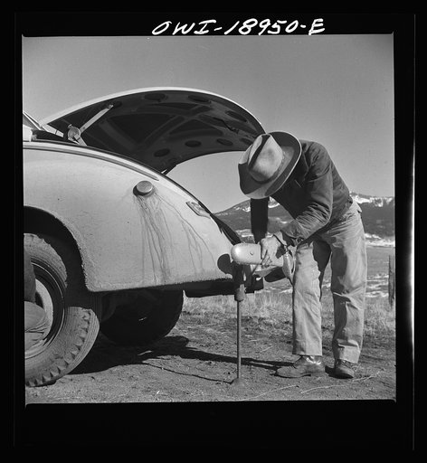 Untitled photo, possibly related to: Moreno Valley, Colfax County, New Mexico. George Turner changing a tire