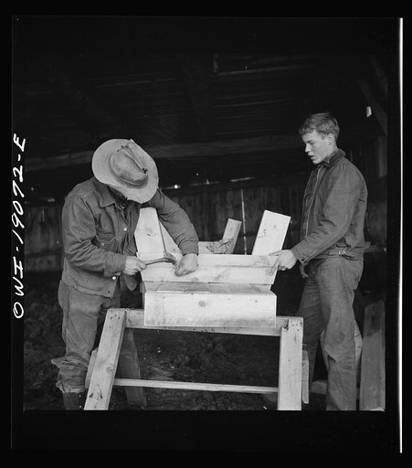 Untitled photo, possibly related to: Moreno Valley, Colfax County, New Mexico. George Mutz and his son building a feed trough