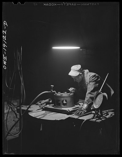 Fort Madison, Iowa. Apparatus for testing diesel cylinder heads for cracks in the diesel head shops of the Atchison, Topeka and Santa Fe Railroad. Water is forced into the head under pressure and with the aid of a small magnifying glass can be seen seeping out through any cracks