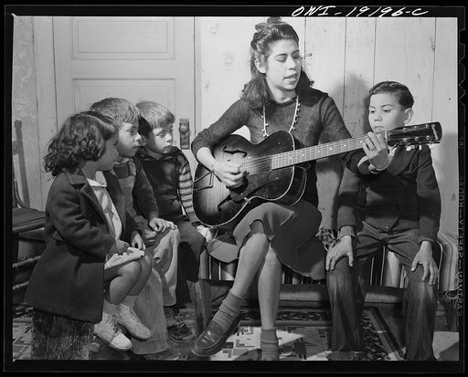 Albuquerque, New Mexico. Spanish-American girl singing folk songs to her little brothers and sisters