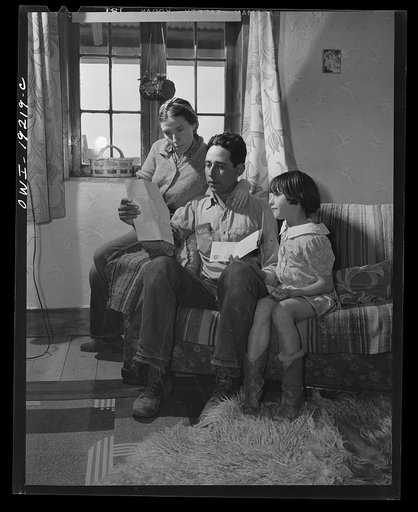 Los Cordovas, Taos County, New Mexico. Blas Chavez with his wife and child, reading a letter announcing that he has won the second prize in the state stock show for the best ram